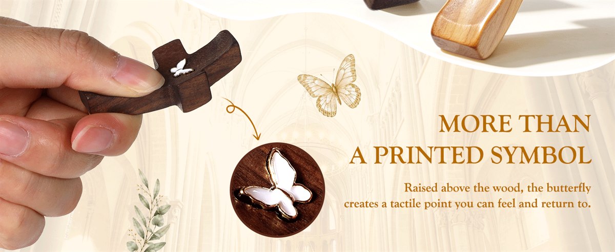 More than a printed symbol — close-up of the raised metal butterfly on a walnut pocket cross, held in hand